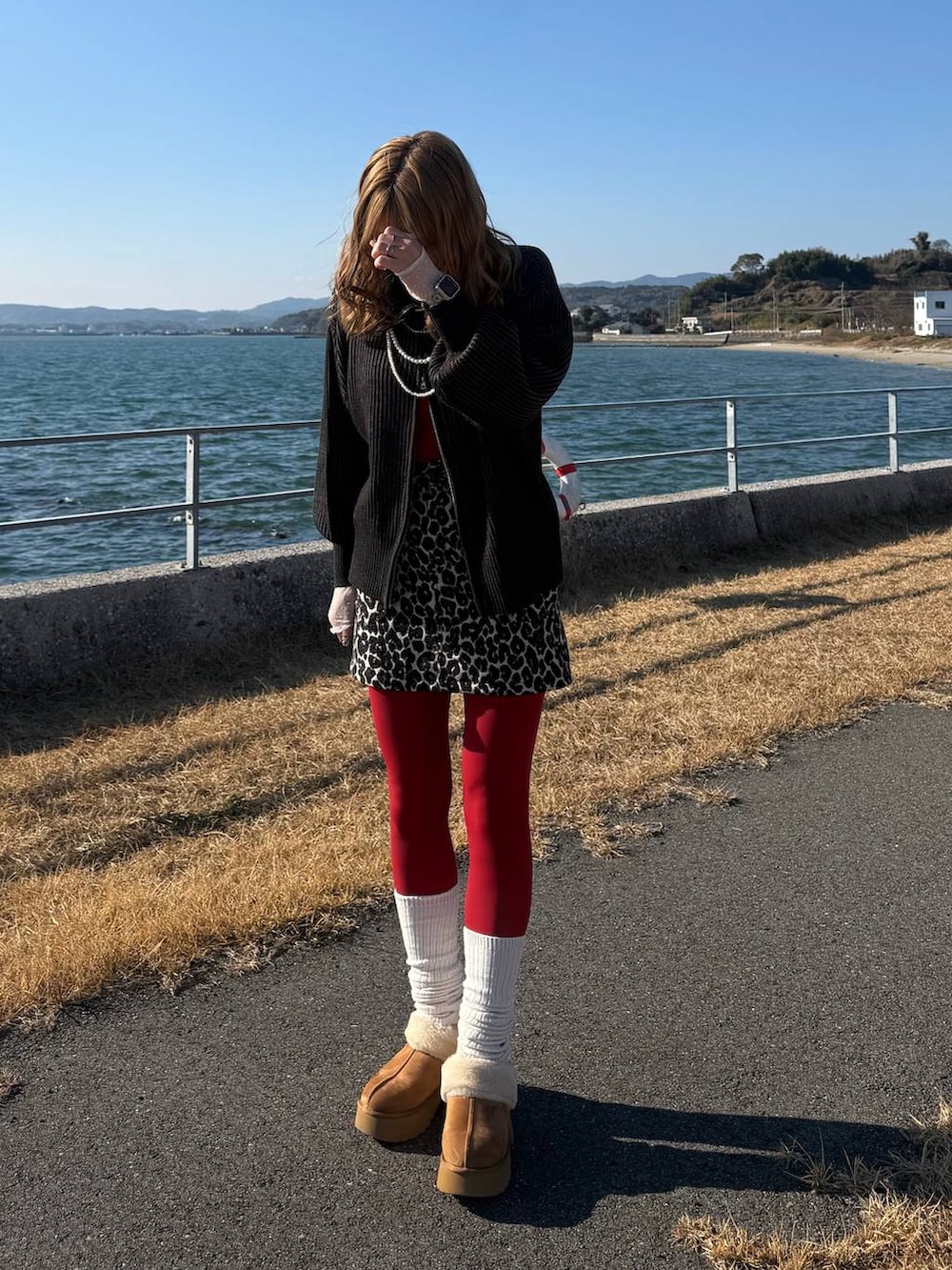 イエロー系のブーツ、ブラック系のニット/セーター、ブラウン系のスカートを着用したレディースの冬コーディネートの4枚目の写真