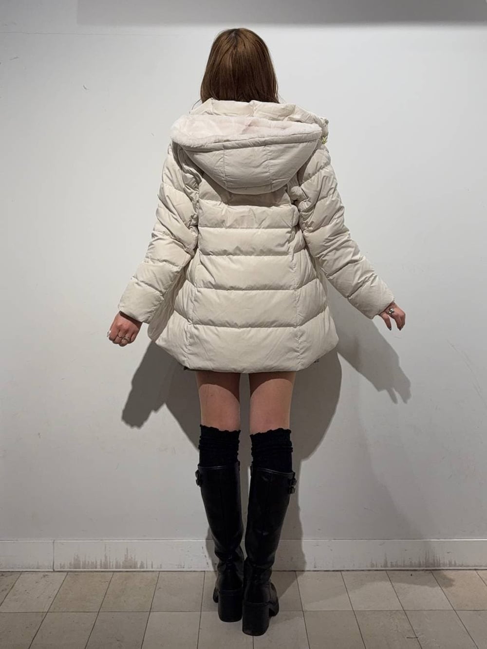 ベージュ系のダウンジャケット/コート、ブラック系のブーツ、シルバー系のネックレスを着用したレディースの冬コーディネートの3枚目の写真