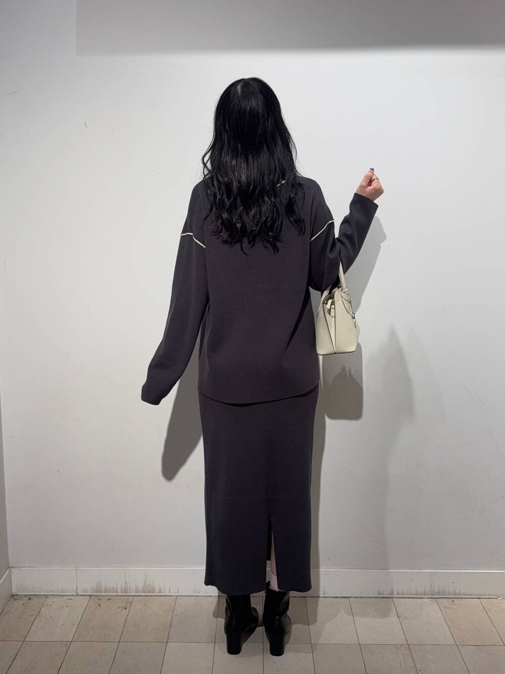 ホワイト系のショルダーバッグ、グレー系のワンピース、ブラック系のブーツを着用したレディースの秋コーディネートの4枚目の写真