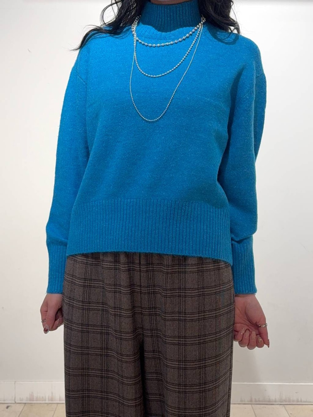 ブルー系のニット/セーター、ブラウン系のその他パンツ、シルバー系のネックレスを着用したレディースの冬コーディネートの3枚目の写真