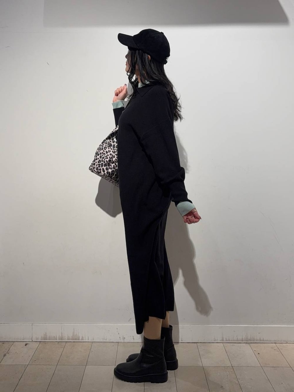 その他のトートバッグ、ブラック系のブーツ、グリーン系のニット/セーターを着用したレディースの冬コーディネートの2枚目の写真