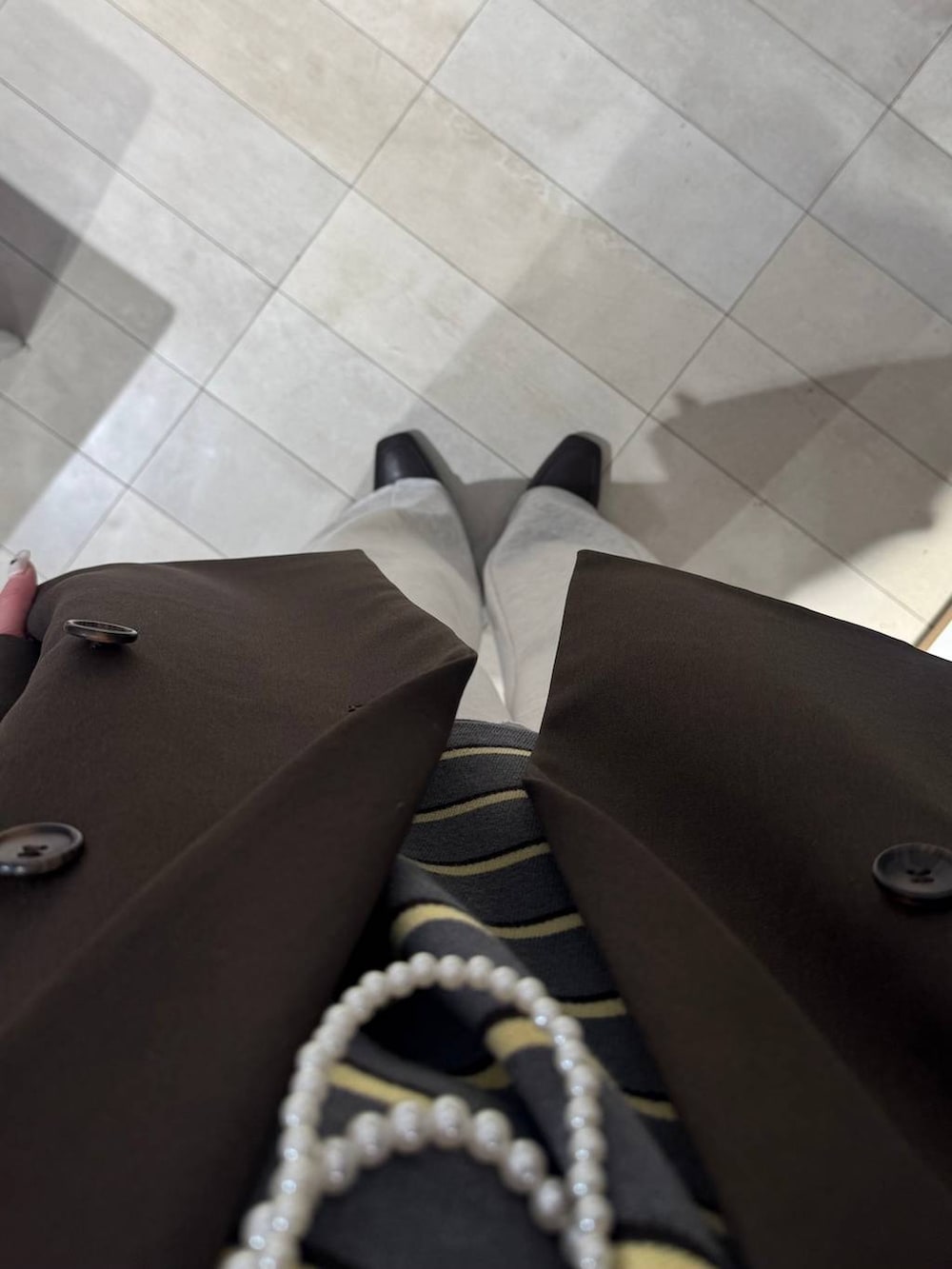 ブラウン系のローファー、ブラウン系のボストンバッグ、ホワイト系のTシャツ/カットソーを着用したレディースの冬コーディネートの6枚目の写真