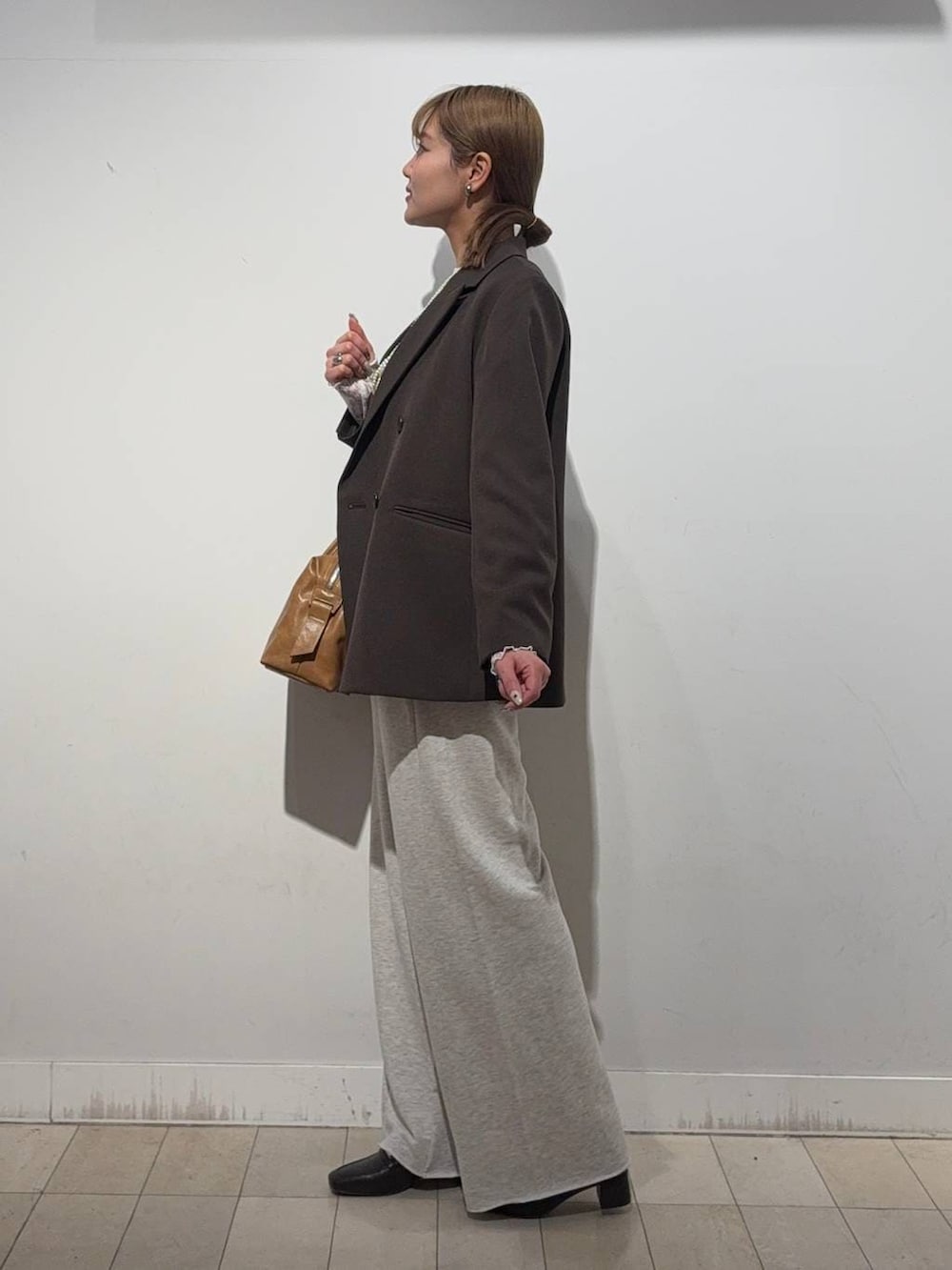 ブラウン系のローファー、ブラウン系のボストンバッグ、ホワイト系のTシャツ/カットソーを着用したレディースの冬コーディネートの3枚目の写真