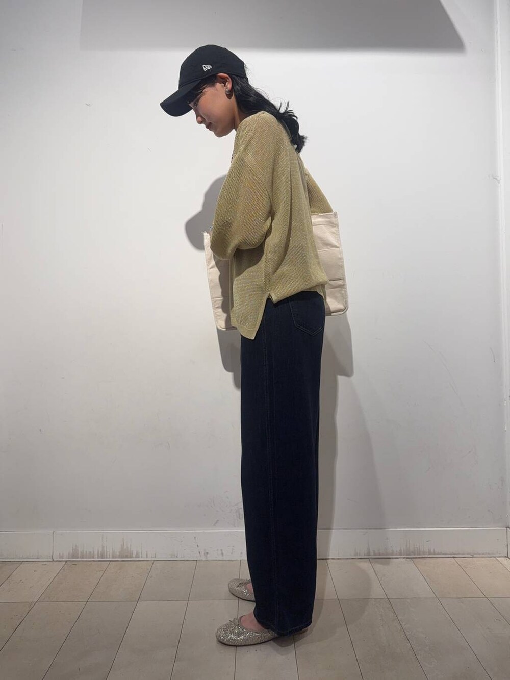 ゴールド系のバレエシューズ、イエロー系のニット/セーター、ブラック系のデニムパンツを着用したレディースの秋コーディネートの3枚目の写真