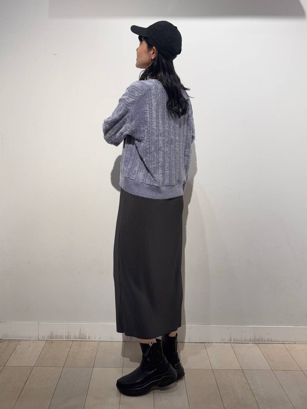 グレー系のスカート、ブラック系のブーツ、パープル系のカーディガン/ボレロを着用したレディースの秋コーディネートの3枚目の写真