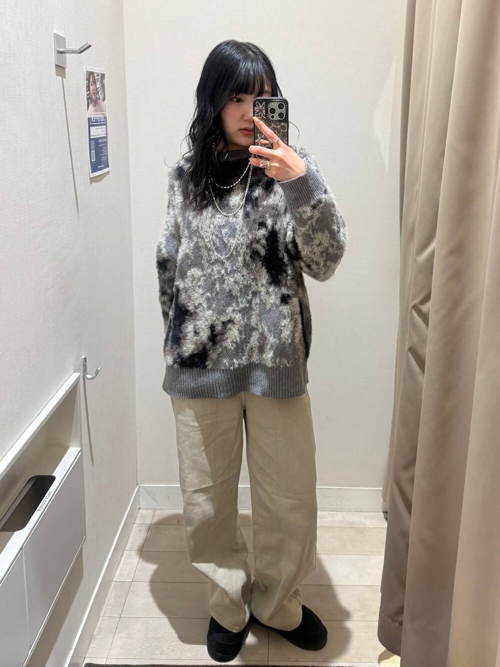 ベージュ系のデニムパンツ、グレー系のワンピース、シルバー系のネックレスを着用したレディースの秋コーディネートの3枚目の写真