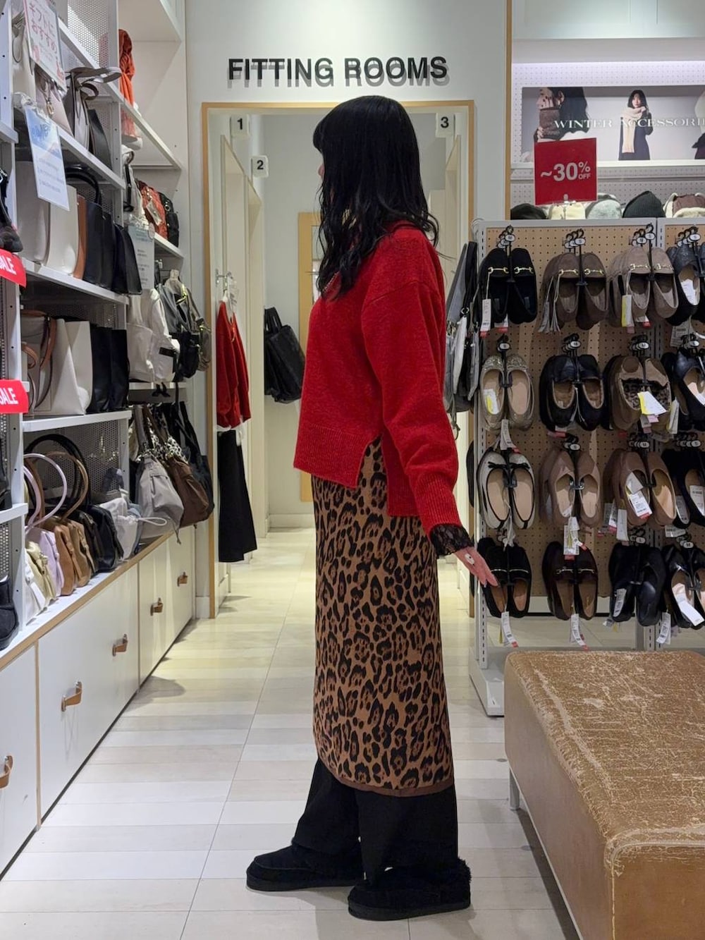 レッド系のニット/セーター、ブラック系のTシャツ/カットソー、ブラック系のスラックスを着用したレディースの冬コーディネートの2枚目の写真