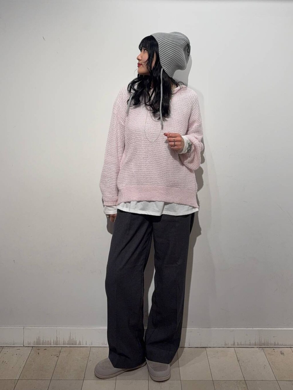 グレー系のチェスターコート、ピンク系のニット/セーター、グレー系のその他パンツを着用したレディースの秋コーディネートの2枚目の写真