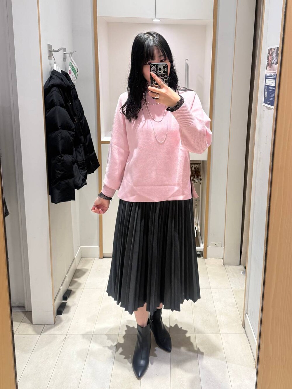 ブラック系のボストンバッグ、ブラック系のTシャツ/カットソー、ピンク系のニット/セーターを着用したレディースの冬コーディネートの4枚目の写真