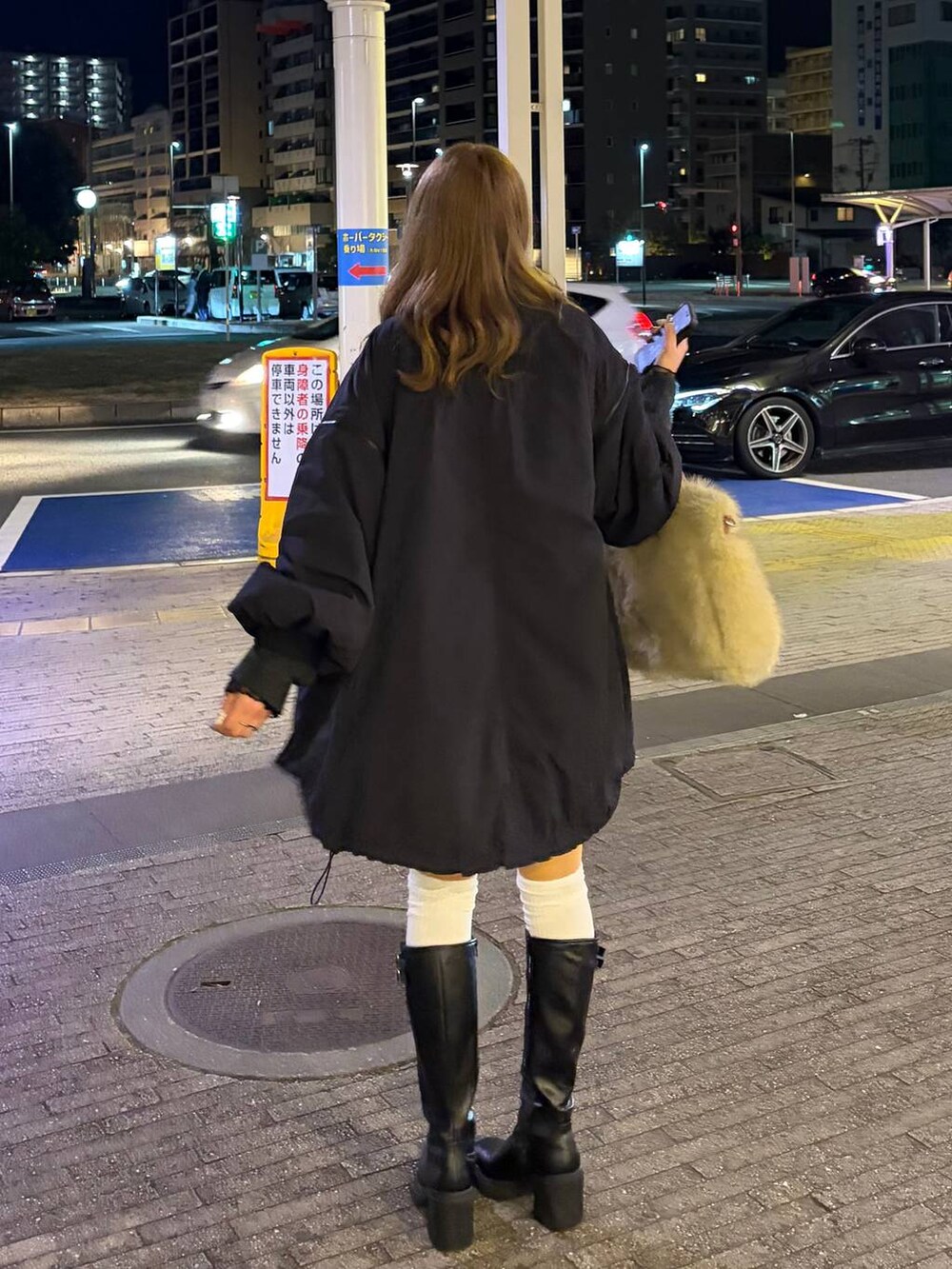 ブラック系のブーツ、ブラウン系のスカート、グレー系のニット/セーターを着用したレディースの冬コーディネートの2枚目の写真