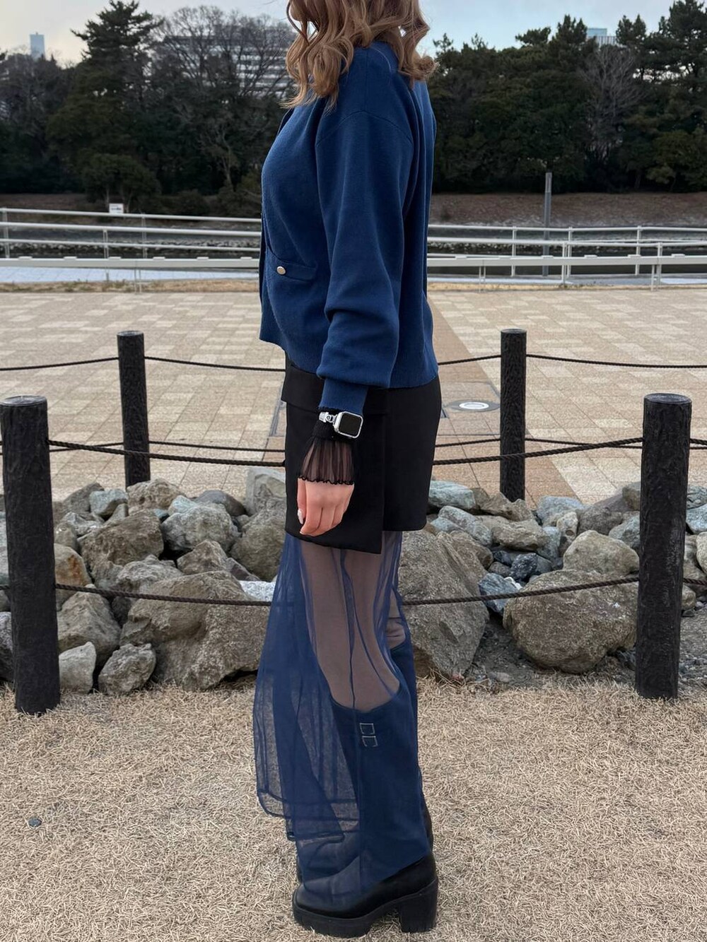 ブラック系のTシャツ/カットソー、ブラック系のブーツ、ホワイト系のネックレスを着用したレディースの冬コーディネートの6枚目の写真