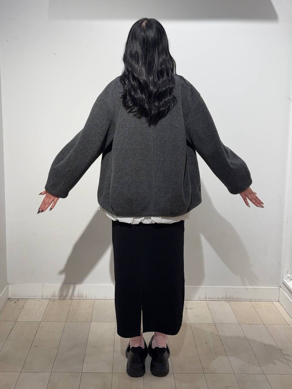 ブラック系のスニーカー、グレー系のノーカラーコート、グレー系のワンピースを着用したレディースの秋コーディネートの2枚目の写真