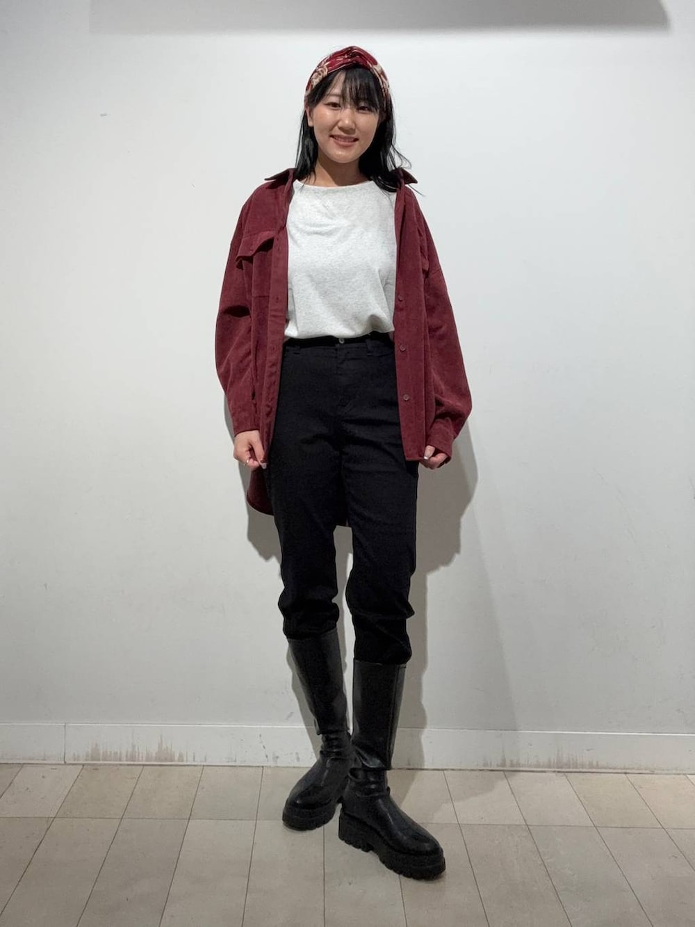 ブラック系のブーツ、ブラック系のデニムパンツ、レッド系のシャツ/ブラウスを着用したレディースの秋コーディネートの2枚目の写真