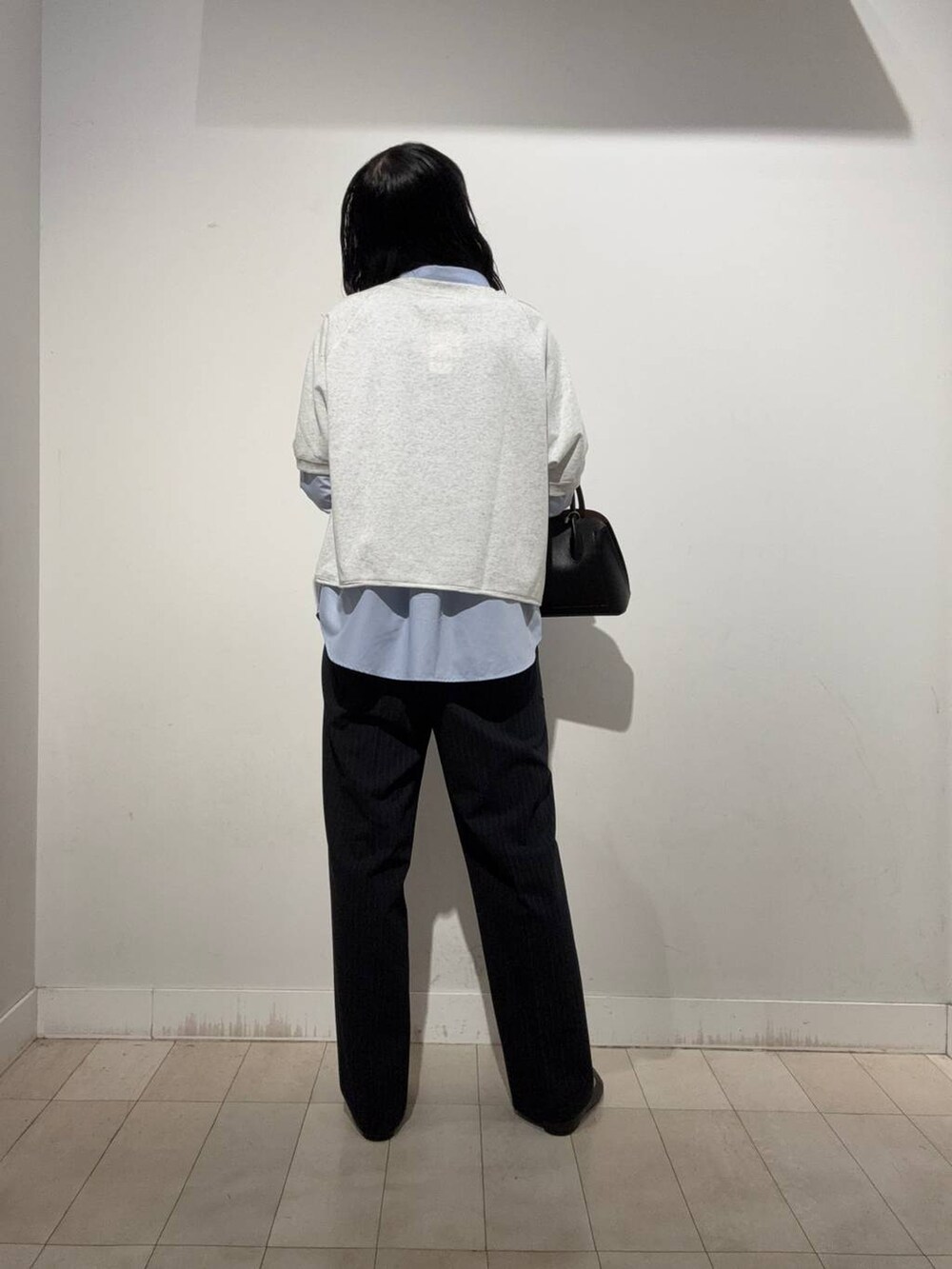 ブラック系のパンプス、ブラック系のショルダーバッグ、グレー系のTシャツ/カットソーを着用したレディースの秋コーディネートの4枚目の写真