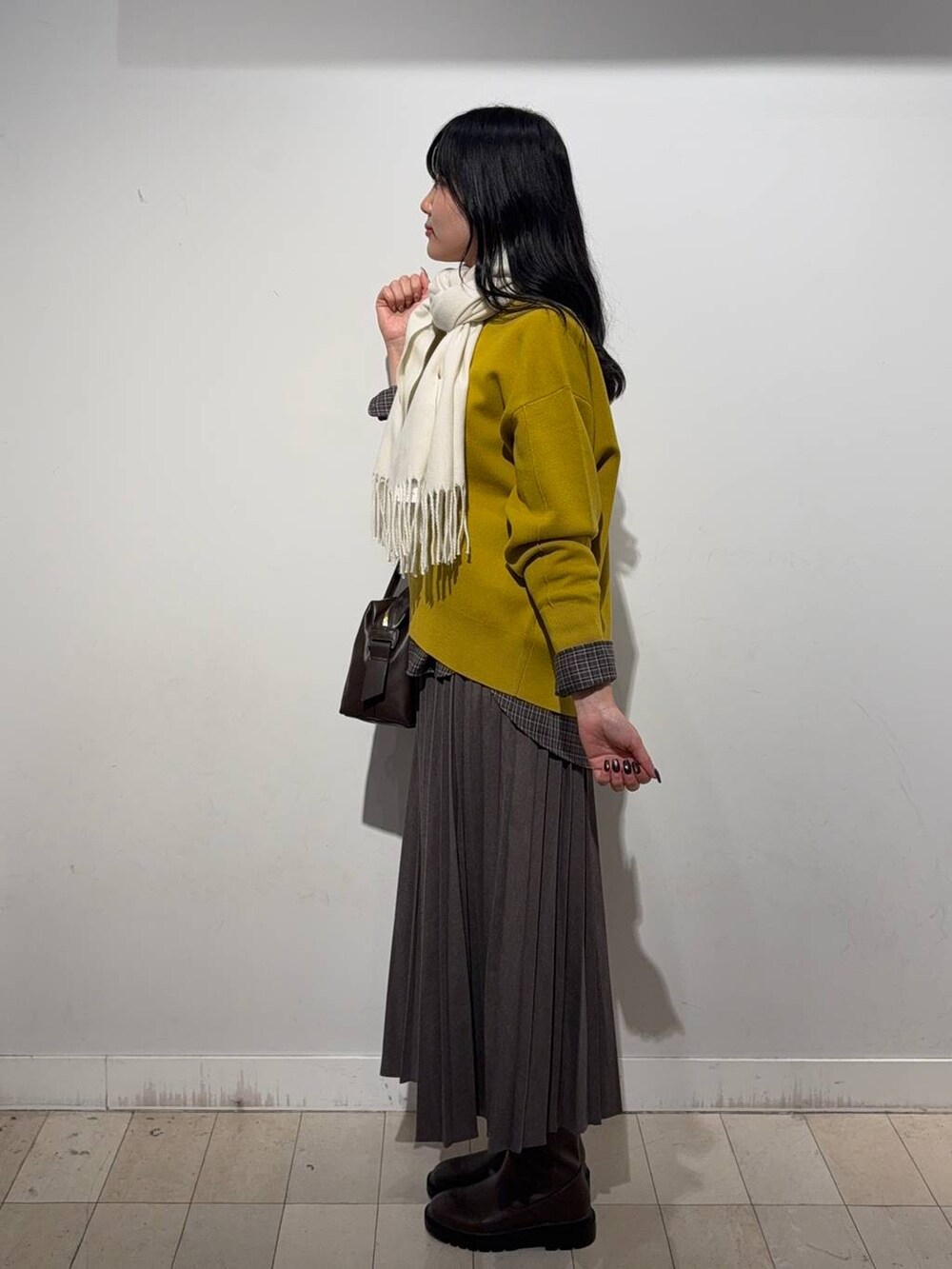 ベージュ系のボストンバッグ、イエロー系のスウェット、ブラウン系のシャツ/ブラウスを着用したレディースの秋コーディネートの2枚目の写真