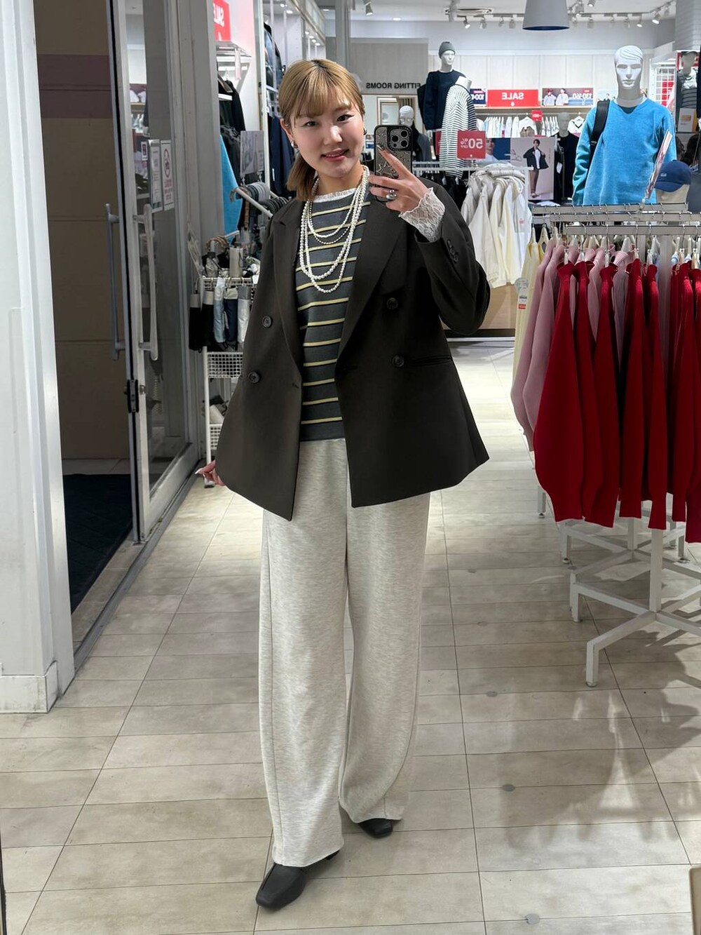 ブラウン系のローファー、ブラウン系のボストンバッグ、ホワイト系のTシャツ/カットソーを着用したレディースの冬コーディネートの7枚目の写真