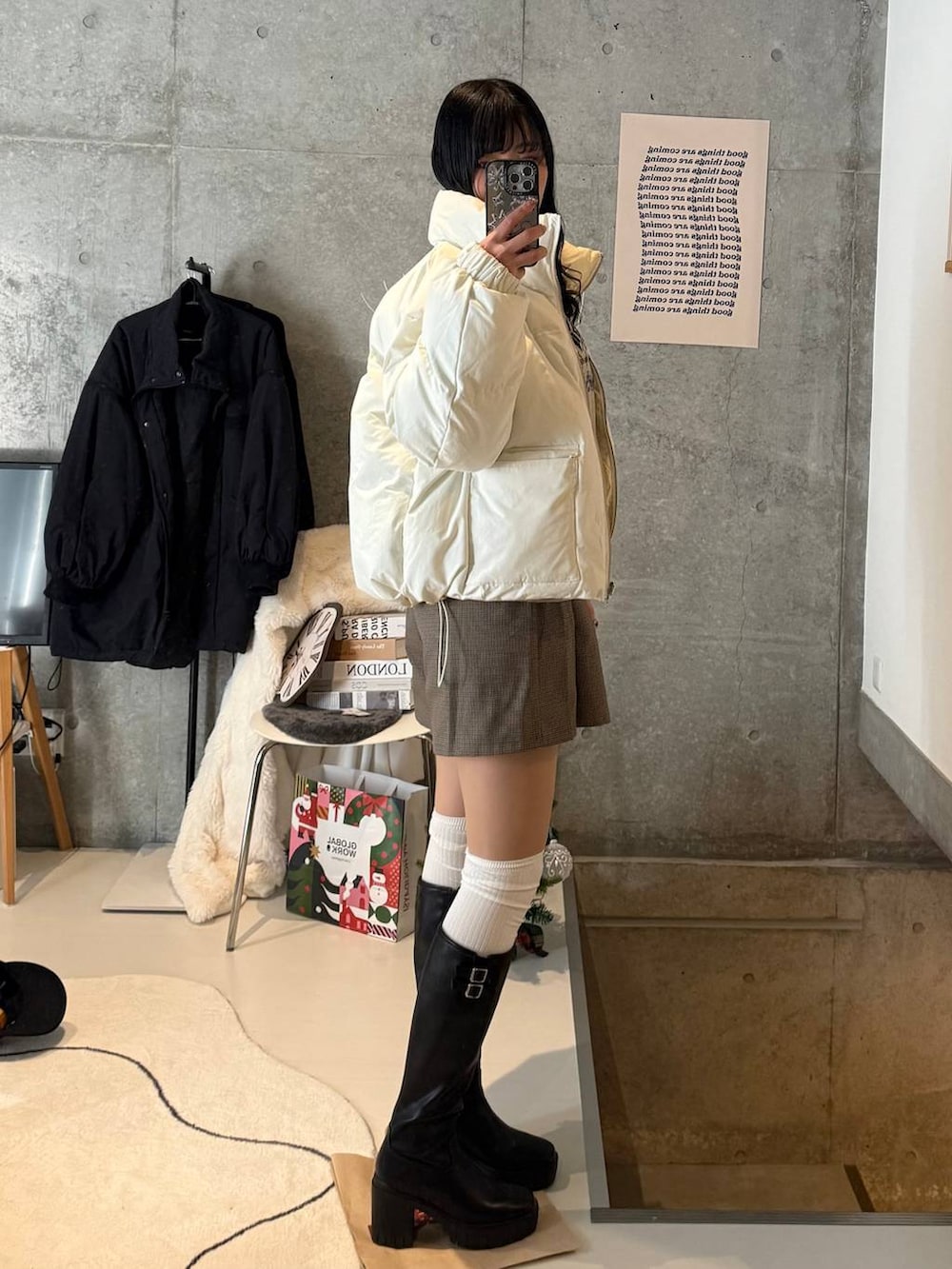 ホワイト系のブルゾン、ブラック系のブーツ、ブラック系のTシャツ/カットソーを着用したレディースの冬コーディネートの2枚目の写真