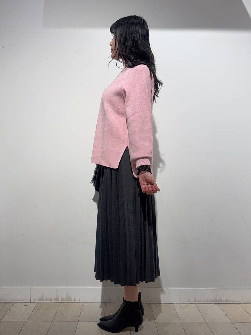 ブラック系のボストンバッグ、ブラック系のTシャツ/カットソー、ピンク系のニット/セーターを着用したレディースの冬コーディネートの2枚目の写真