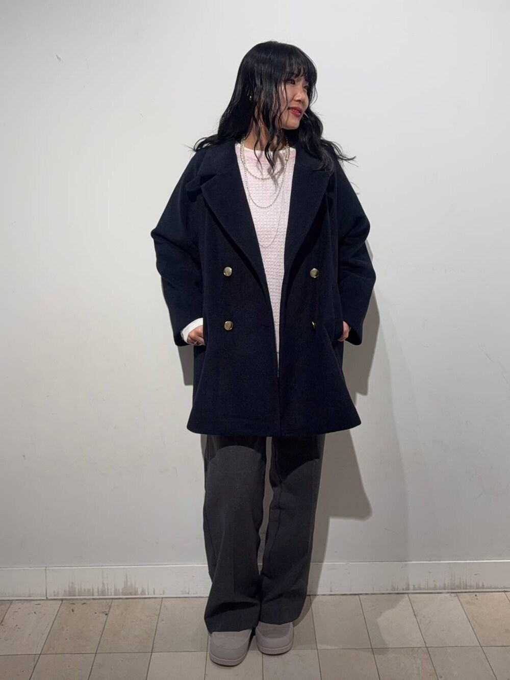 グレー系のチェスターコート、ピンク系のニット/セーター、グレー系のその他パンツを着用したレディースの秋コーディネートの3枚目の写真