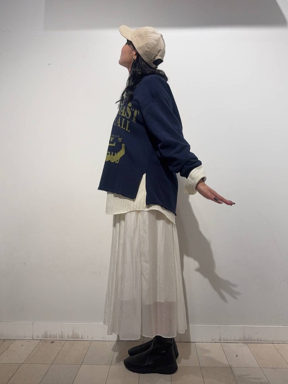 ベージュ系のスカート、ブラウン系のブーツ、イエロー系のシャツ/ブラウスを着用したレディースの秋コーディネートの3枚目の写真