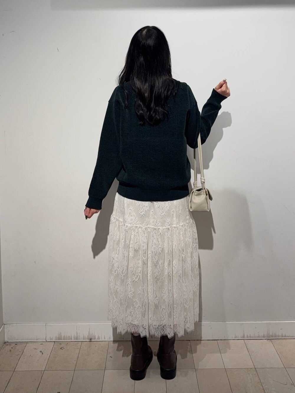 ベージュ系のショルダーバッグ、グレー系のワンピース、ブラウン系のブーツを着用したレディースの秋コーディネートの3枚目の写真