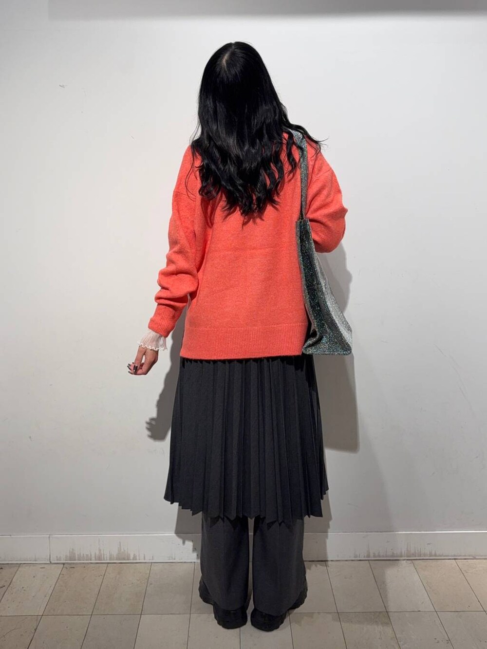 シルバー系のトートバッグ、ブラック系のスニーカー、ホワイト系のTシャツ/カットソーを着用したレディースの秋コーディネートの3枚目の写真