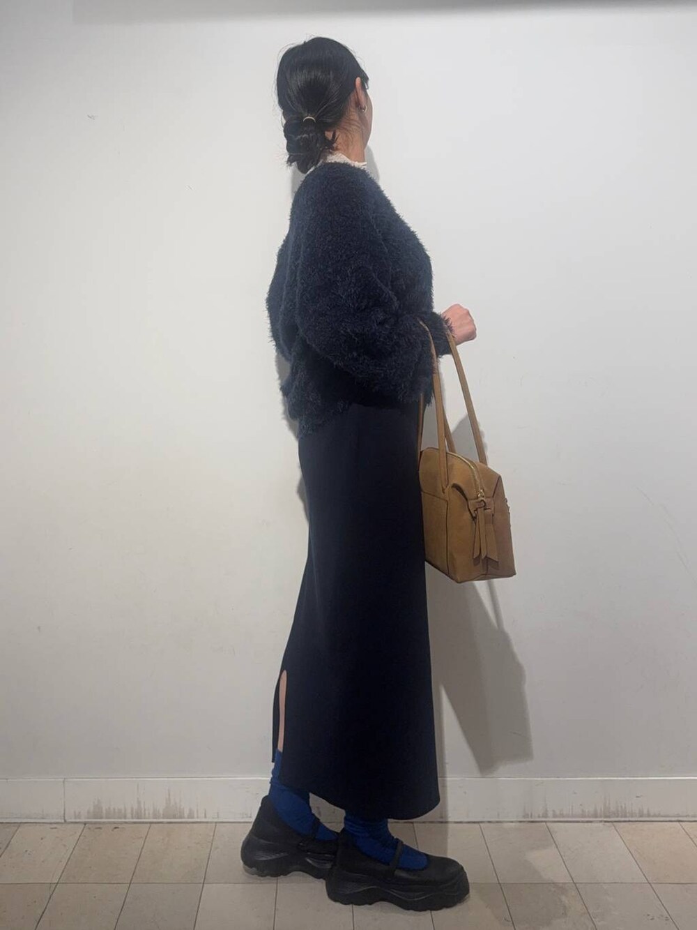 ブラック系のスニーカー、ベージュ系のボストンバッグ、ブルー系のワンピースを着用したレディースの秋コーディネートの3枚目の写真