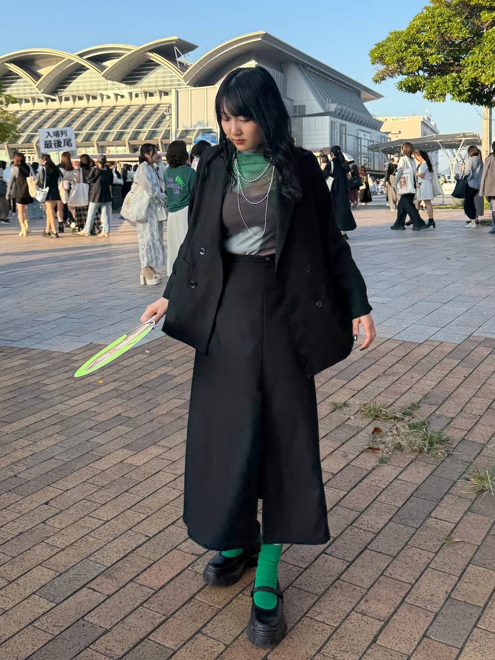 ブラック系のスニーカー、ブラック系のテーラードジャケット、シルバー系のネックレスを着用したレディースの秋コーディネートの2枚目の写真