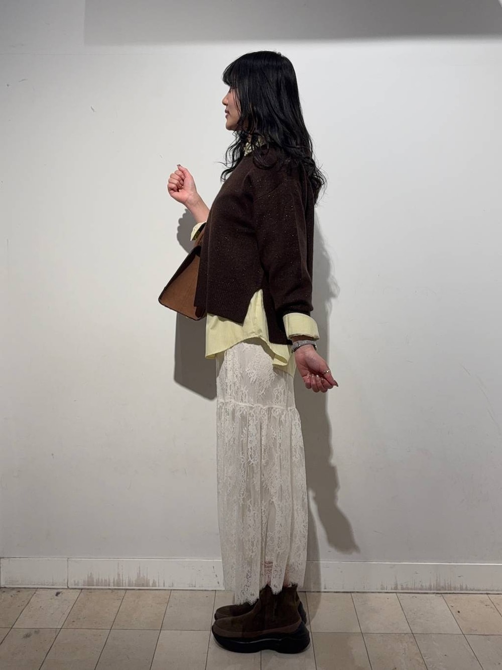 イエロー系のシャツ/ブラウス、ブラウン系のニット/セーター、ベージュ系のショルダーバッグを着用したレディースの冬コーディネートの3枚目の写真