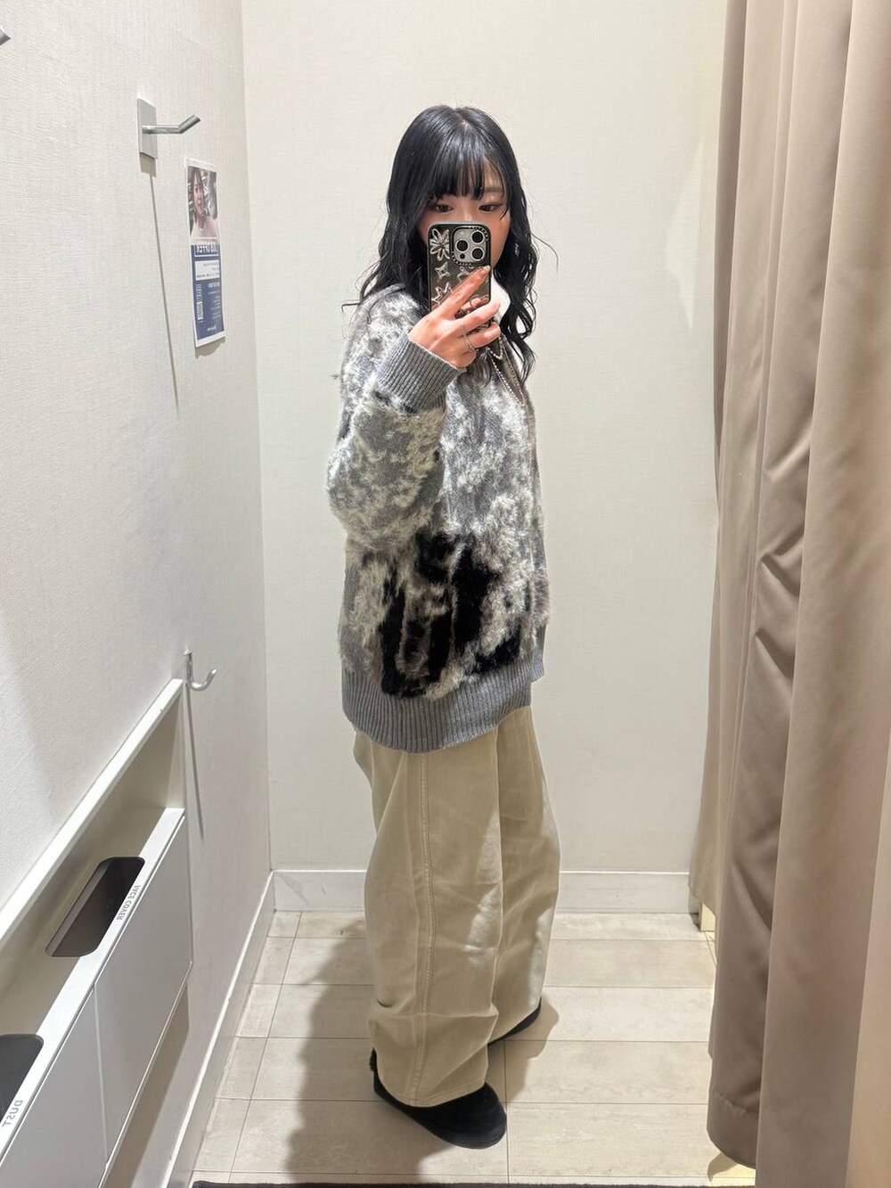 ベージュ系のデニムパンツ、グレー系のワンピース、シルバー系のネックレスを着用したレディースの秋コーディネートの2枚目の写真