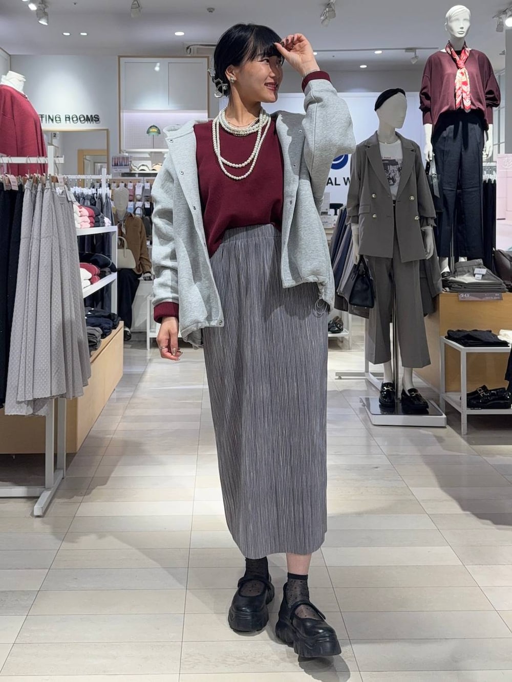 ブラック系のスニーカー、ブラウン系のスウェット、グレー系のスカートを着用したレディースの秋コーディネートの4枚目の写真