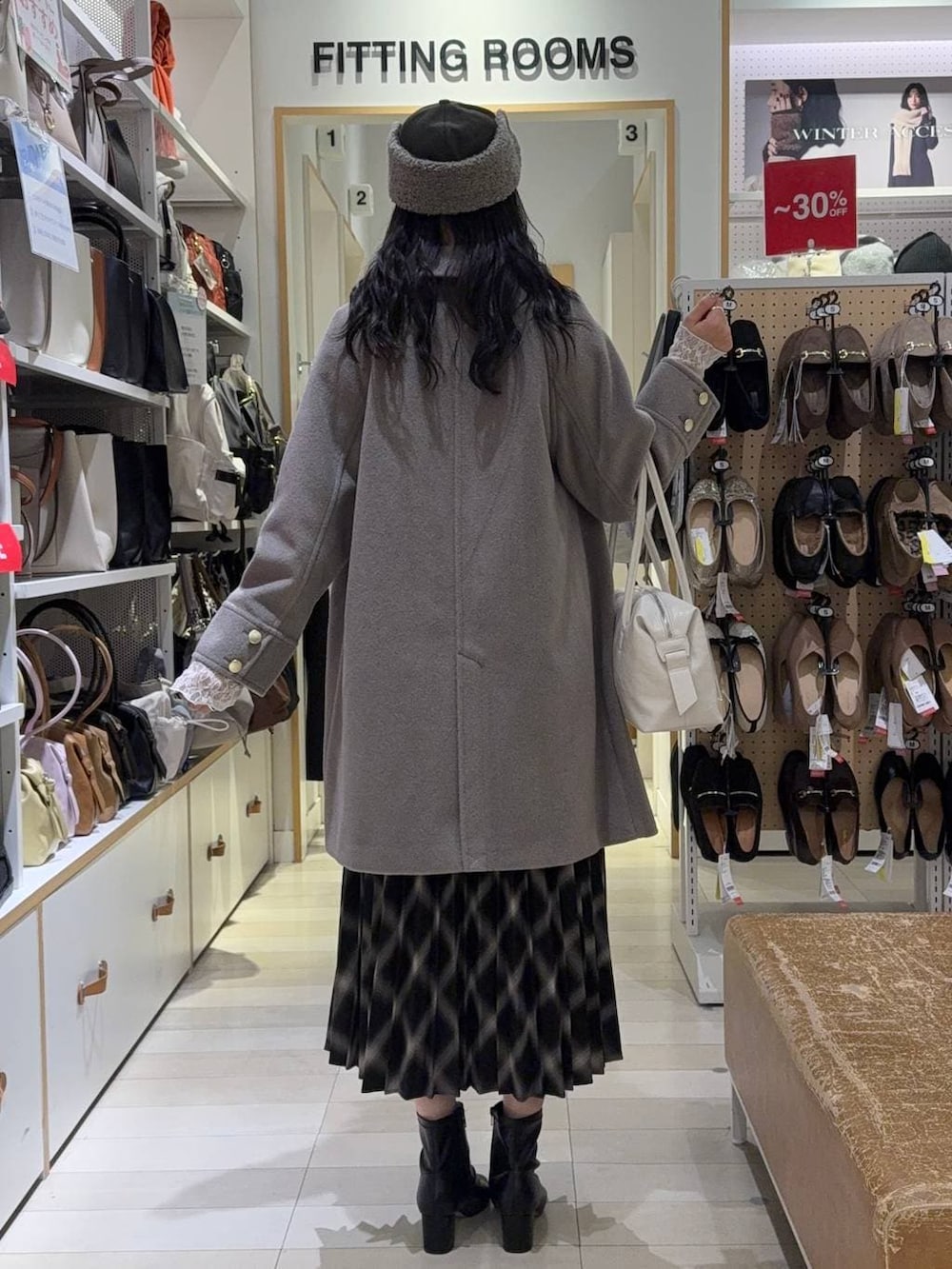 パープル系のボストンバッグ、ベージュ系のチェスターコート、ピンク系のニット/セーターを着用したレディースの冬コーディネートの3枚目の写真