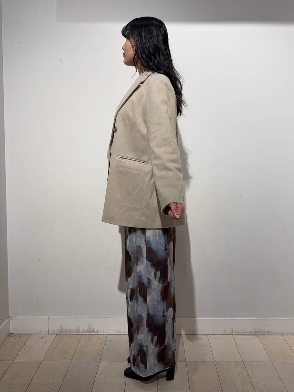 ブラック系のショルダーバッグ、ブラウン系のニット/セーター、ブラック系のブーツを着用したレディースの冬コーディネートの2枚目の写真