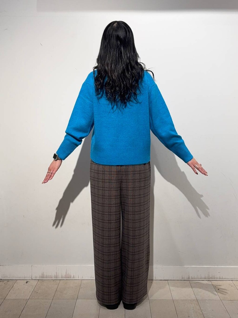 ブルー系のニット/セーター、ブラウン系のその他パンツ、シルバー系のネックレスを着用したレディースの冬コーディネートの4枚目の写真