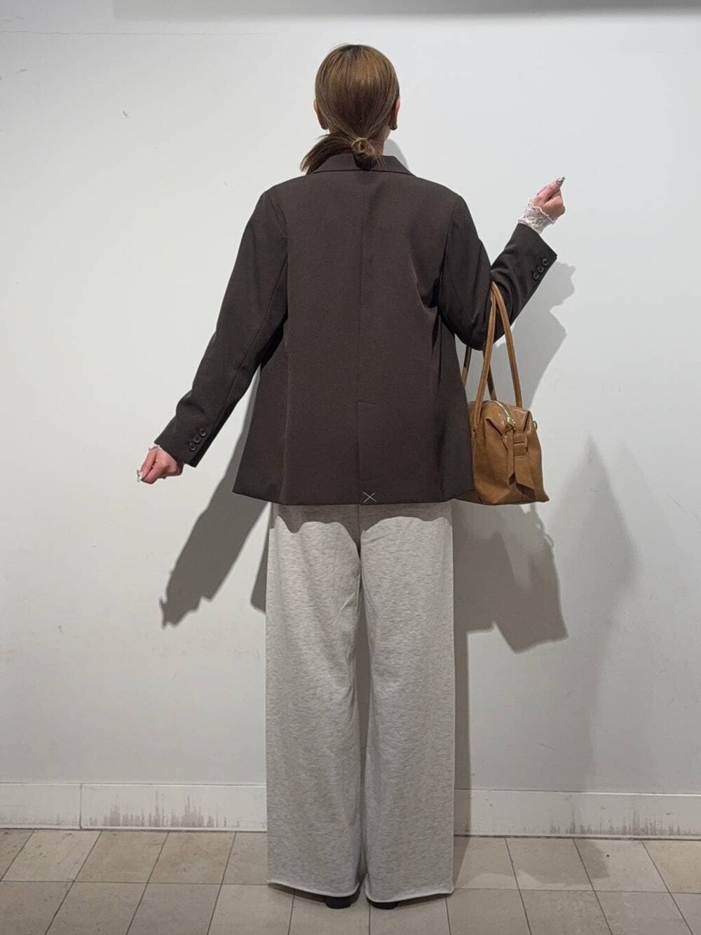 ブラウン系のローファー、ブラウン系のボストンバッグ、ホワイト系のTシャツ/カットソーを着用したレディースの冬コーディネートの4枚目の写真