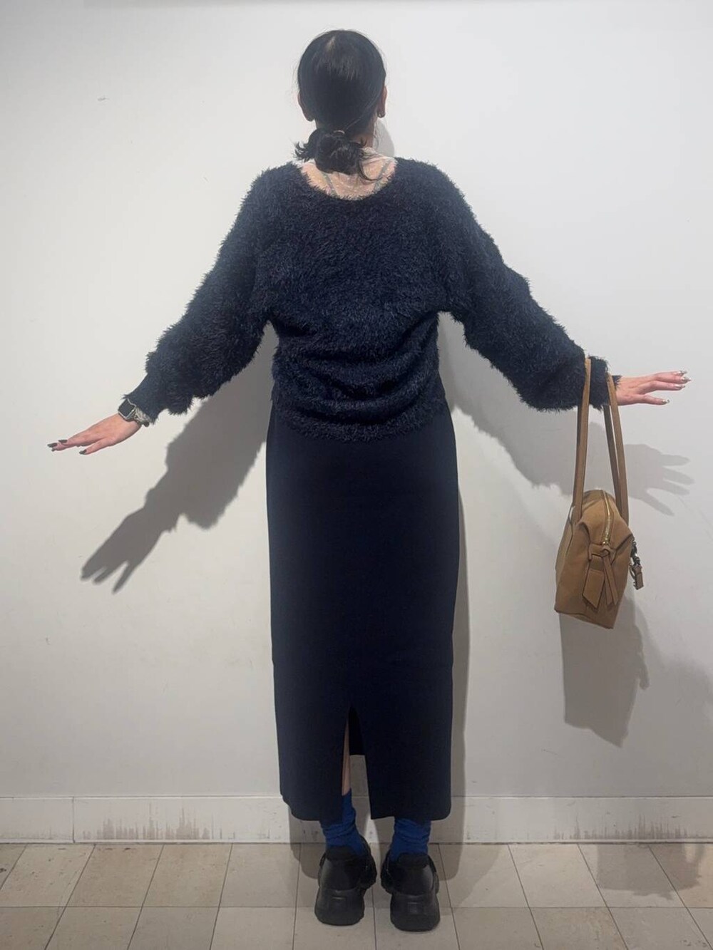 ブラック系のスニーカー、ベージュ系のボストンバッグ、ブルー系のワンピースを着用したレディースの秋コーディネートの2枚目の写真