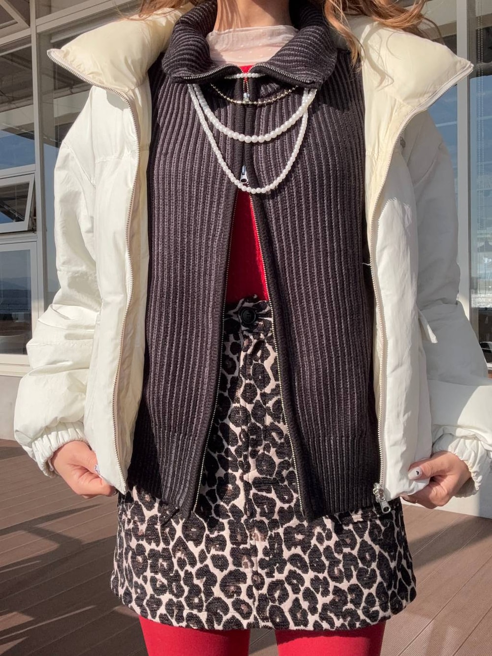 イエロー系のブーツ、ブラック系のニット/セーター、ブラウン系のスカートを着用したレディースの冬コーディネートの5枚目の写真