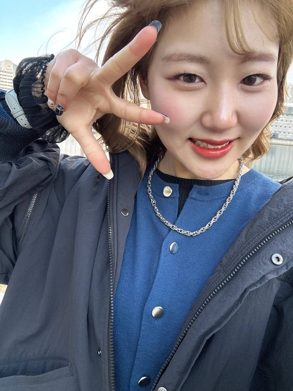 ブラック系のTシャツ/カットソー、ブラック系のブーツ、ホワイト系のネックレスを着用したレディースの冬コーディネートの3枚目の写真