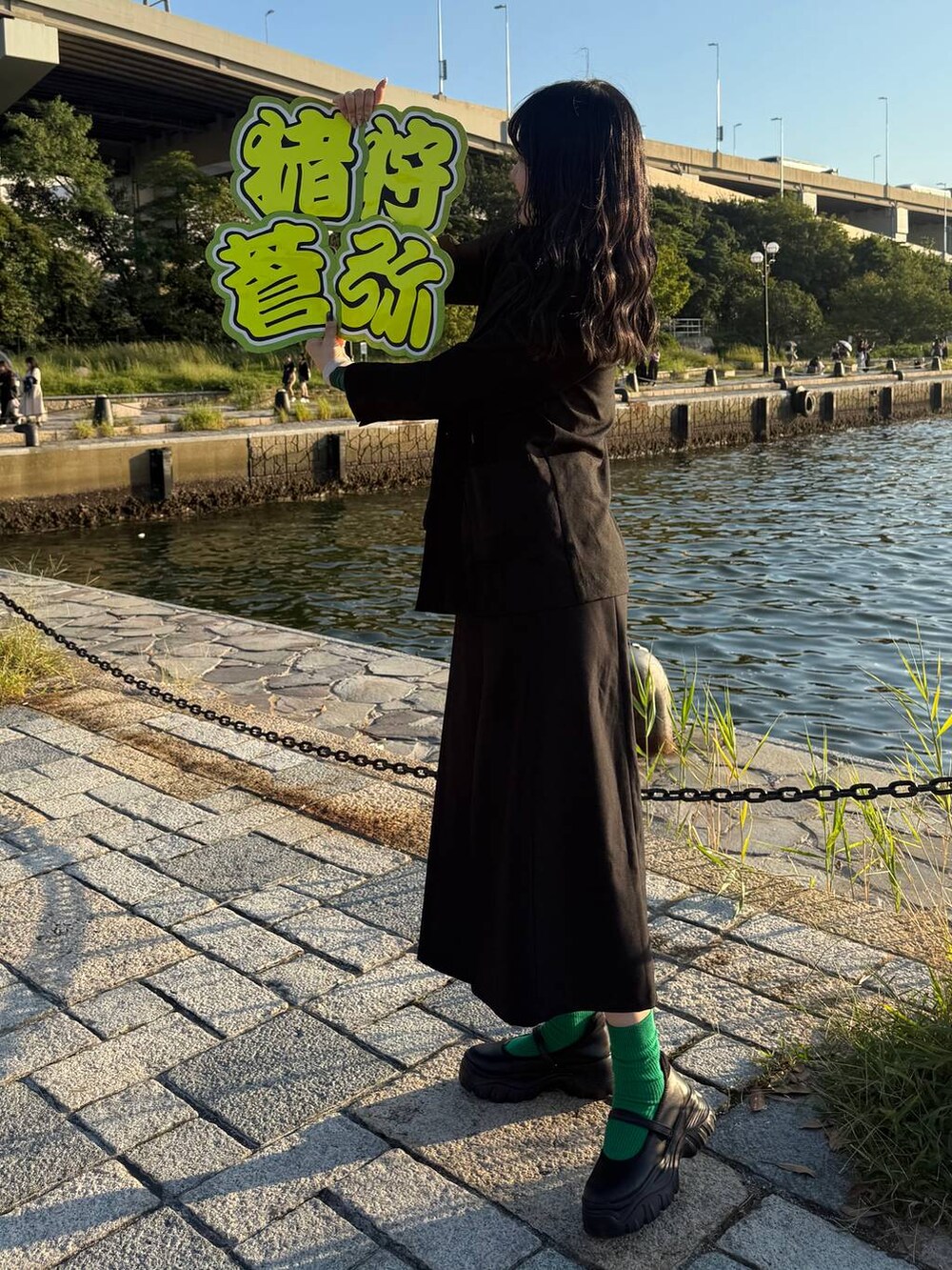 ブラック系のスニーカー、ブラック系のテーラードジャケット、シルバー系のネックレスを着用したレディースの秋コーディネートの4枚目の写真