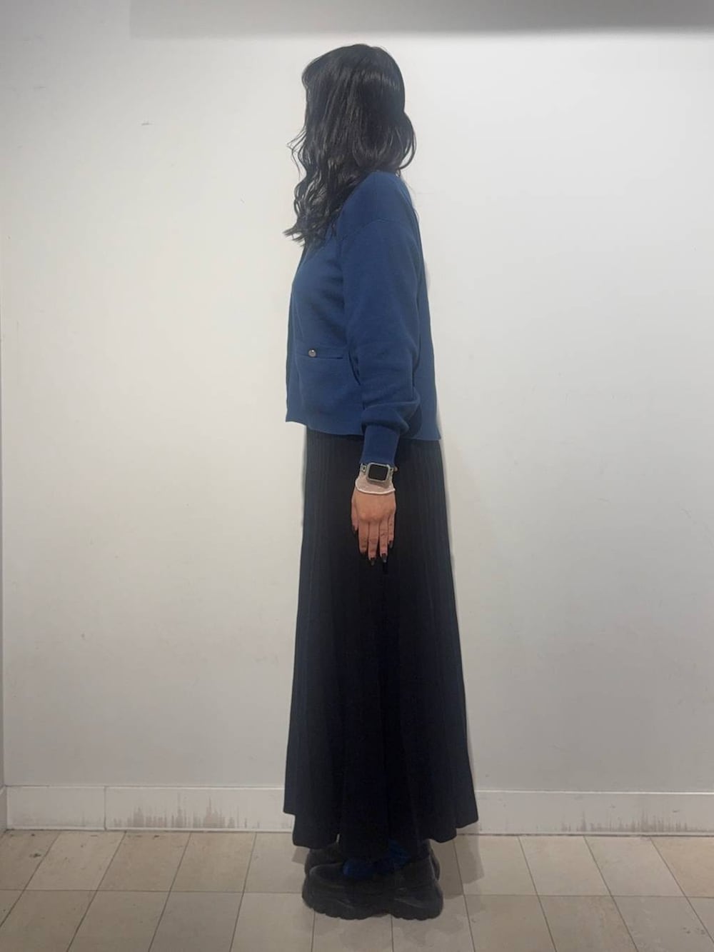 ブラック系のスニーカー、ブルー系のカーディガン/ボレロ、ブラック系のスカートを着用したレディースの秋コーディネートの4枚目の写真