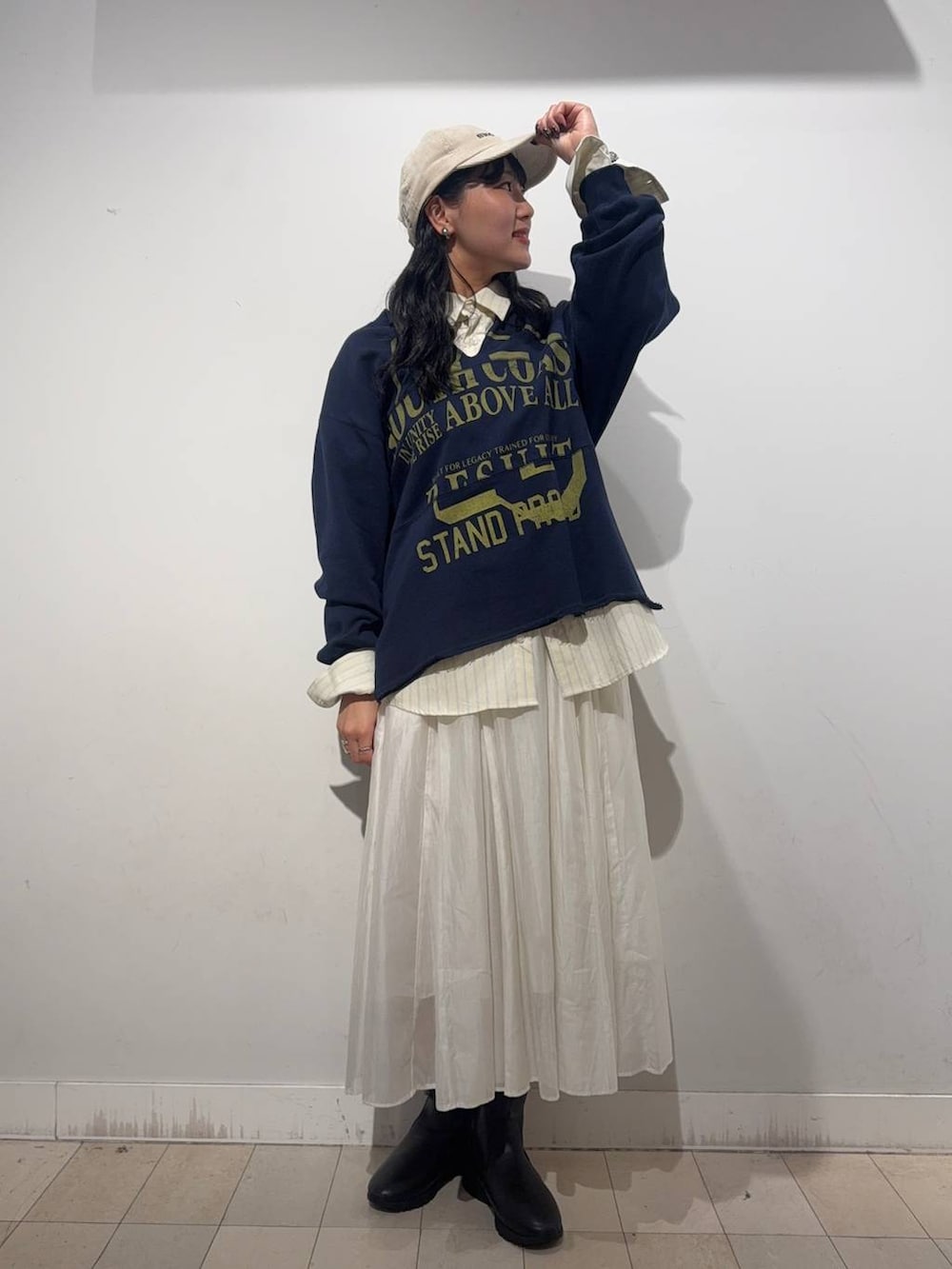 ベージュ系のスカート、ブラウン系のブーツ、イエロー系のシャツ/ブラウスを着用したレディースの秋コーディネートの2枚目の写真