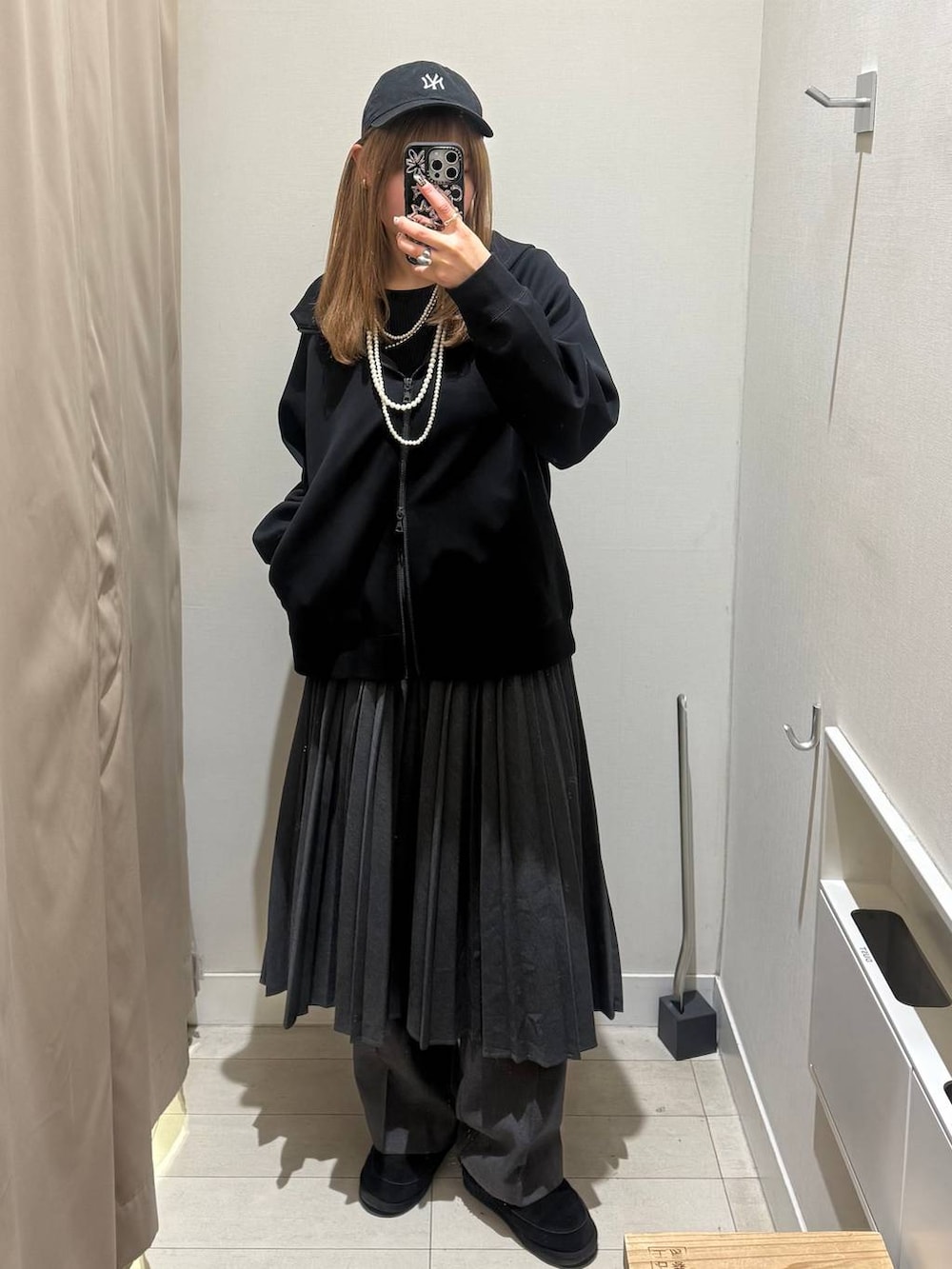 グレー系のその他パンツ、グレー系のスカート、ブラック系のパーカーを着用したレディースの冬コーディネートの2枚目の写真