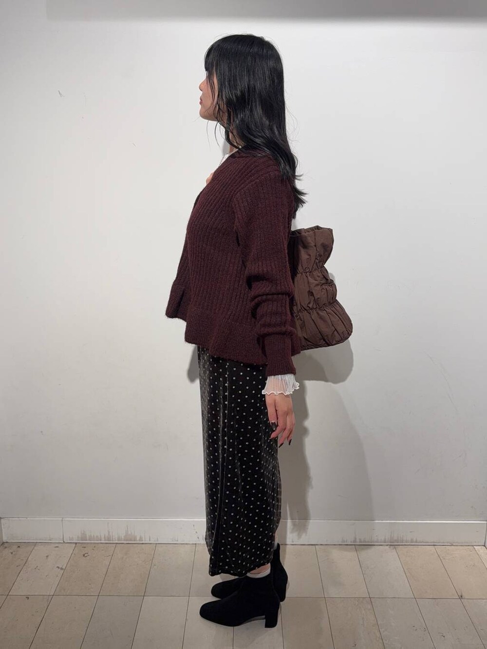 ホワイト系のTシャツ/カットソー、ブラウン系のスカート、その他のブーツを着用したレディースの秋コーディネートの2枚目の写真