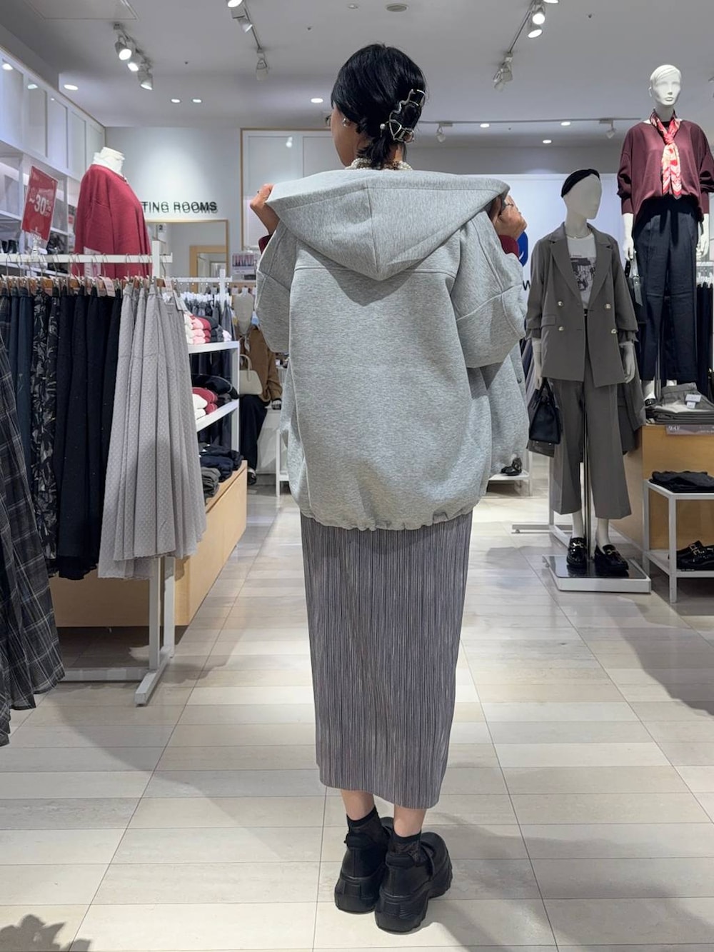 ブラック系のスニーカー、ブラウン系のスウェット、グレー系のスカートを着用したレディースの秋コーディネートの3枚目の写真