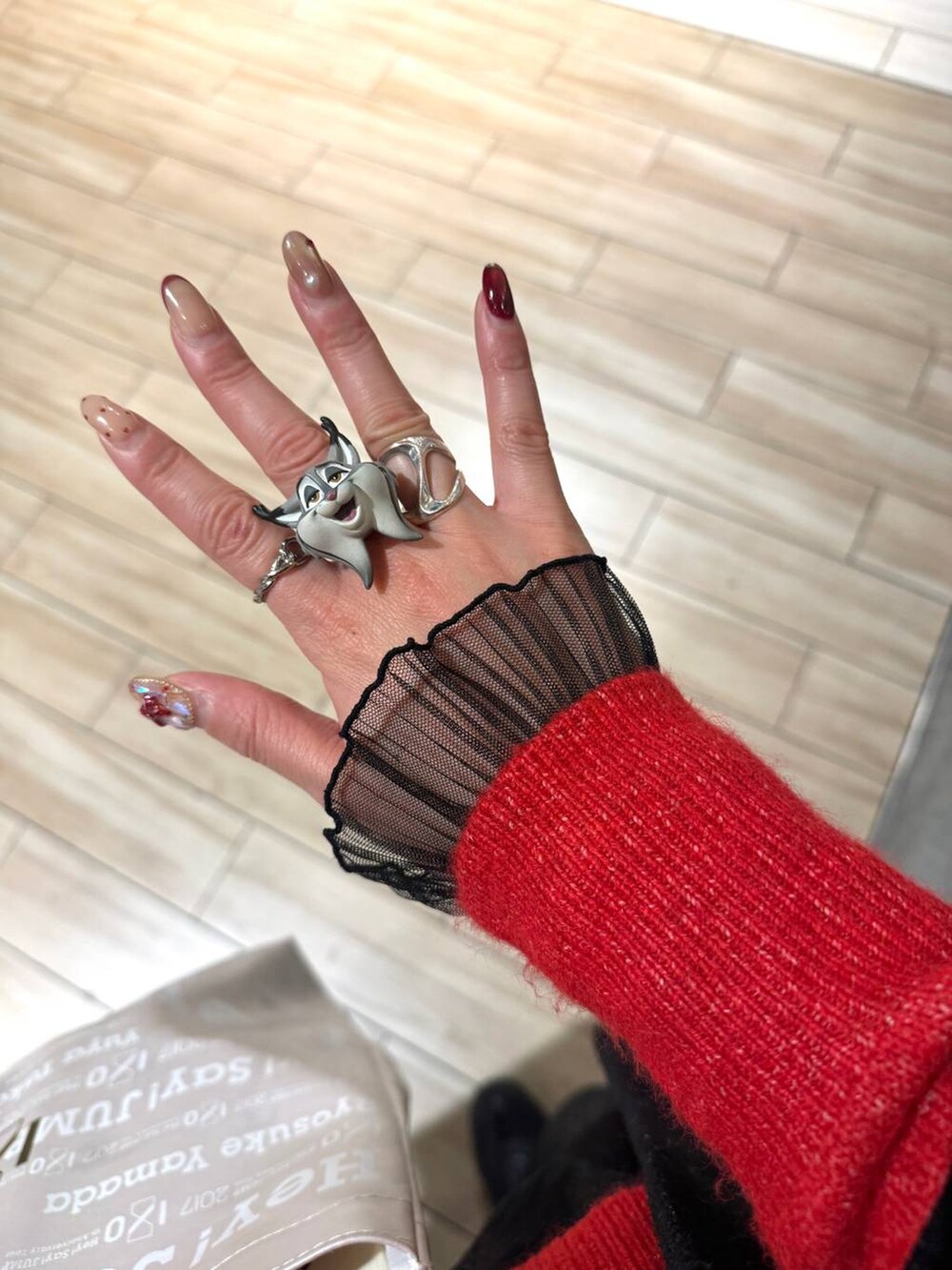 レッド系のニット/セーター、ブラック系のTシャツ/カットソー、ブラック系のその他パンツを着用したレディースの冬コーディネートの4枚目の写真