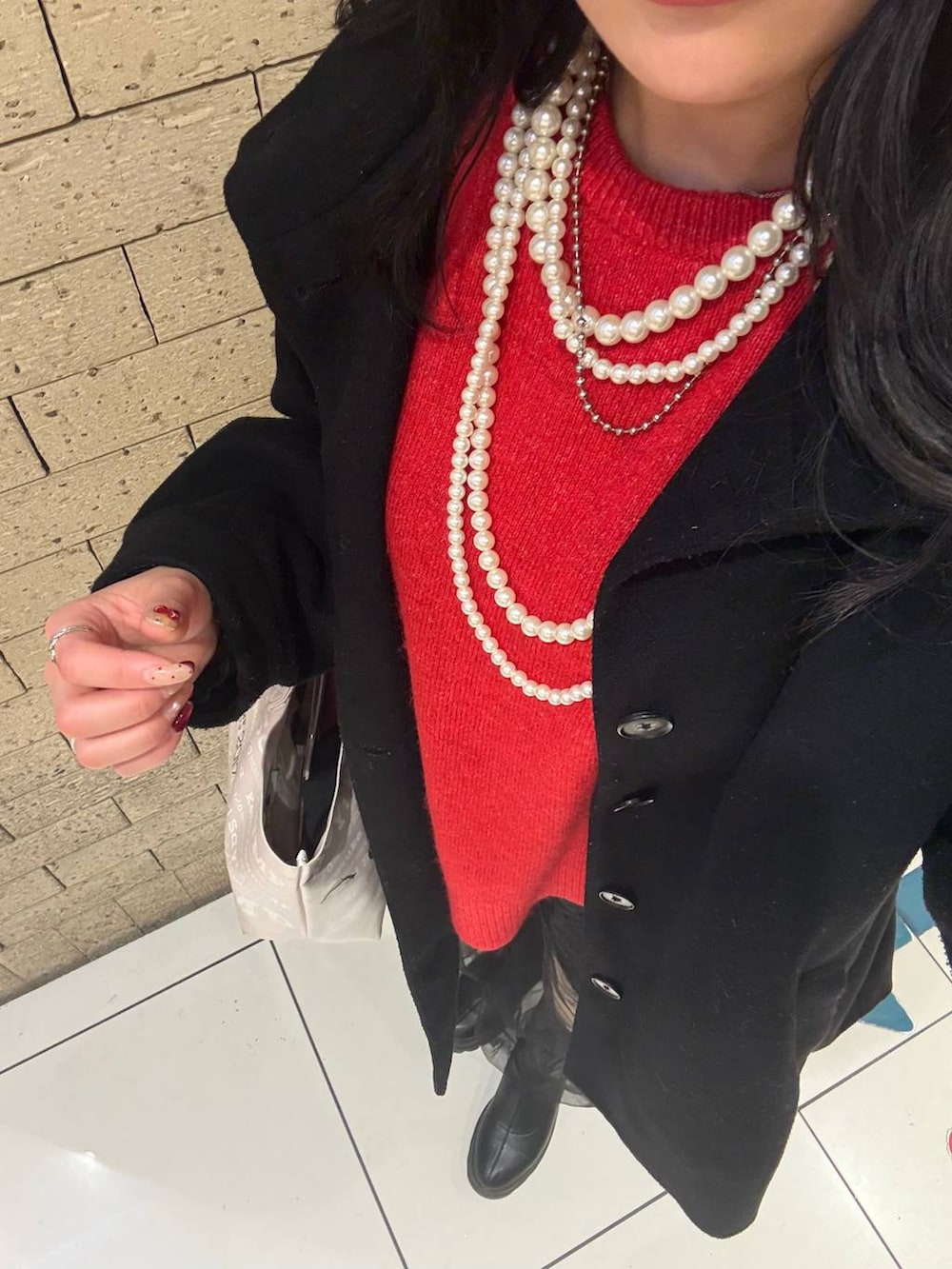 レッド系のニット/セーター、ブラック系のTシャツ/カットソー、ブラック系のその他パンツを着用したレディースの冬コーディネートの3枚目の写真