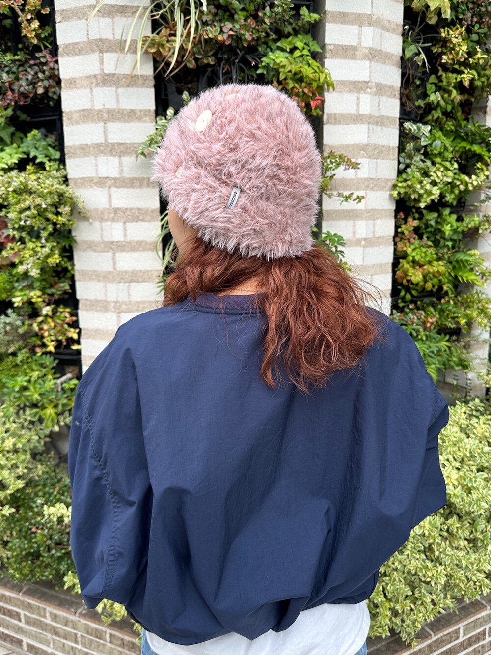 ピンク系のニットキャップ/ビーニーを着用したレディースの秋コーディネートの7枚目の写真