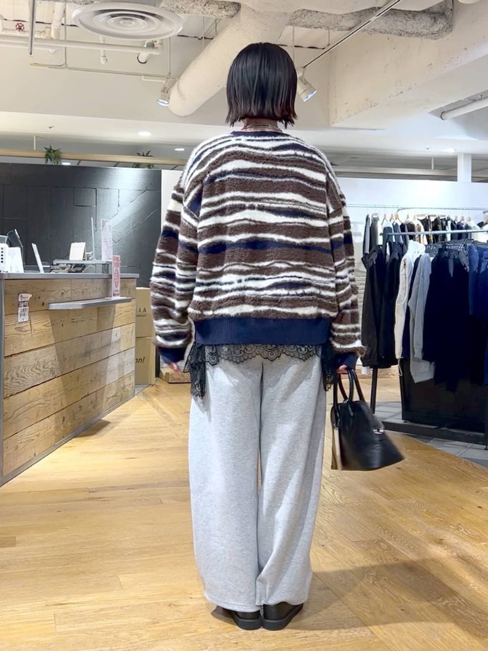 ブラック系のその他シューズ、ブラック系のボストンバッグ、ブラック系のTシャツ/カットソーを着用したレディースの冬コーディネートの4枚目の写真