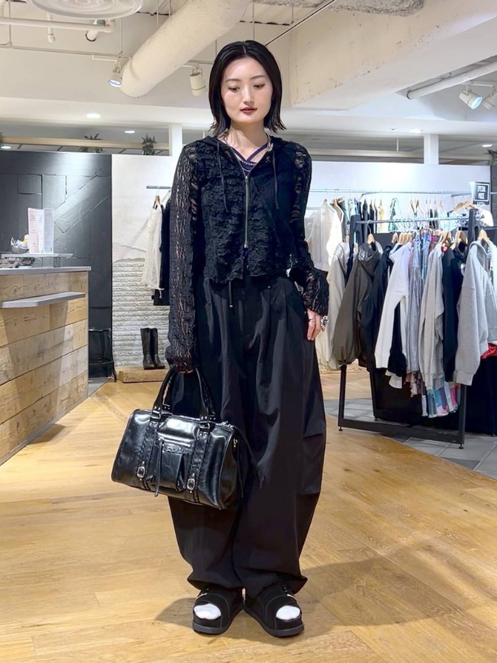 ブラック系のボストンバッグ、ブルー系のタンクトップ、ブラック系のその他パンツを着用したレディースの春コーディネートの2枚目の写真