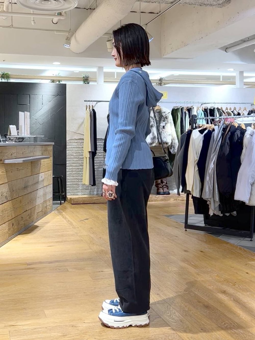 ブラック系のスウェットパンツ、ブルー系のスニーカー、ブラック系のボストンバッグを着用したレディースの冬コーディネートの3枚目の写真